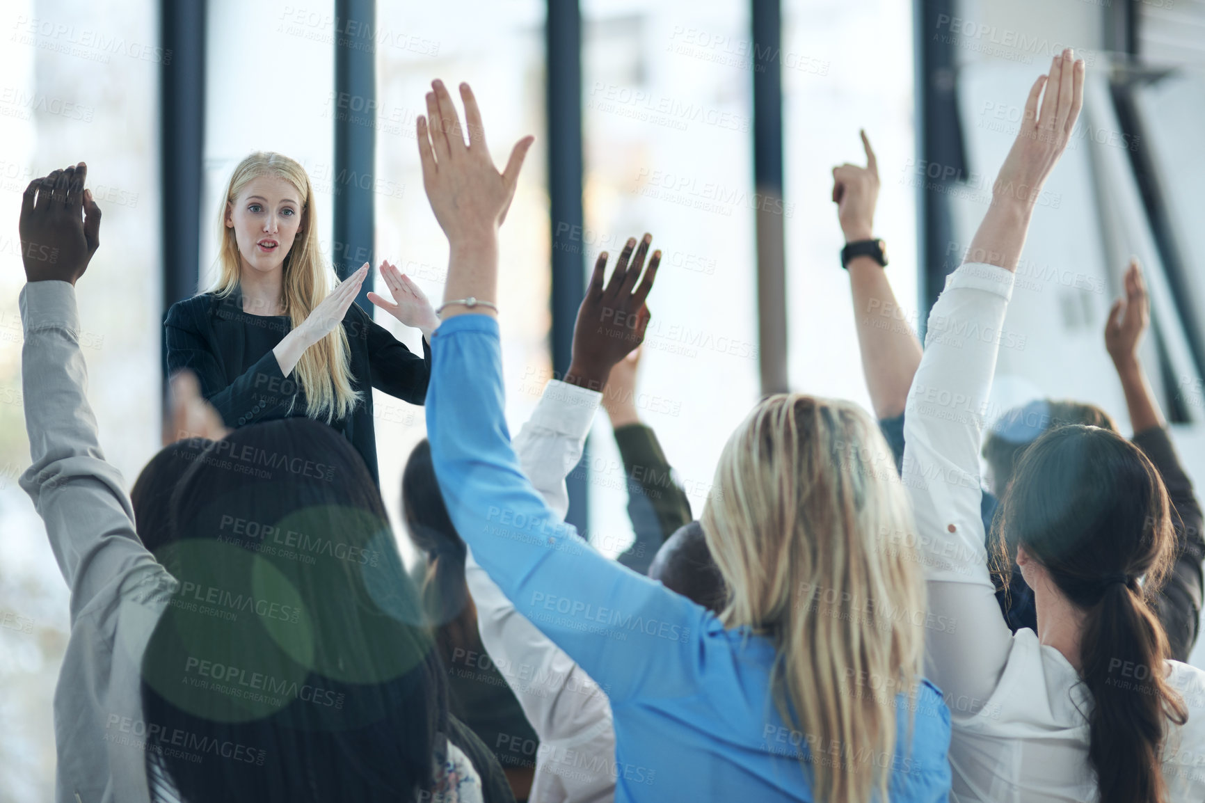 Buy stock photo Shot of a group of people raising their hands in a class