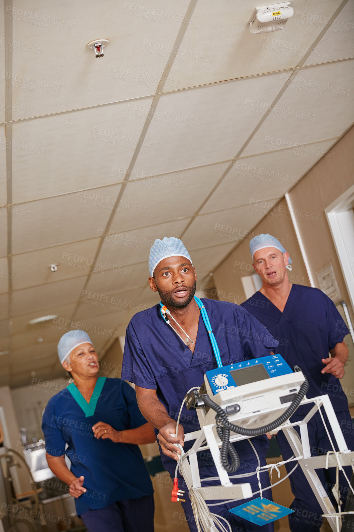 Buy stock photo Shot of a medical team rushing through a hospital corridor