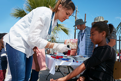 Buy stock photo Cropped shot of volunteer nurses giving checkups to underprivileged kids