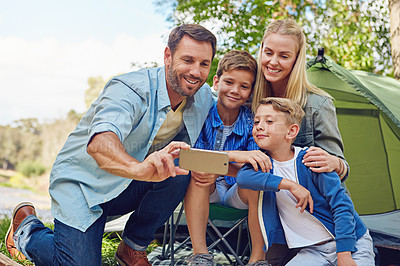 Buy stock photo Cropped shot of a family of four taking a selfie while camping