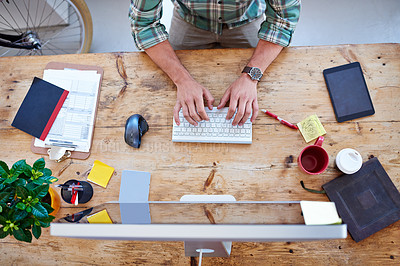 Buy stock photo Overhead shot of a creative professional's desk while he is typing on his wireless keyboard