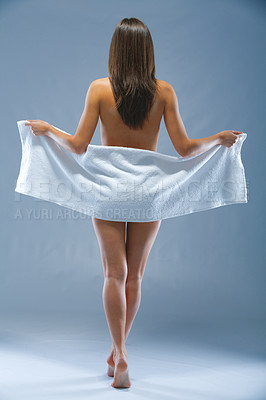 Buy stock photo Rearview shot of a topless woman covering her behind with a towel