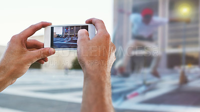 Buy stock photo Cropped shot of a man taking a picture of his friend doing tricks on his skateboard