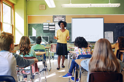 Buy stock photo Shot of a young teacher educating a group of elementary children