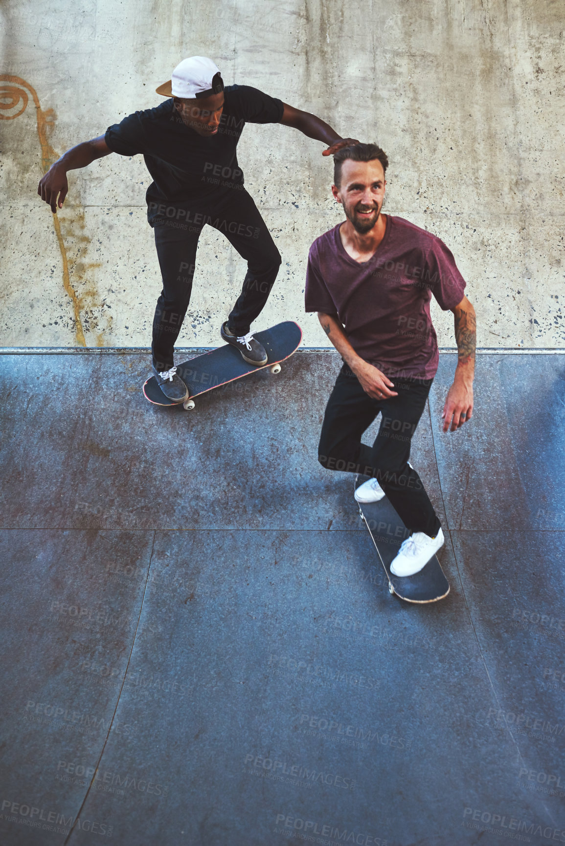 Buy stock photo Shot of two young men skating at the skatepark