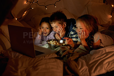 Buy stock photo Shot of three young children using a laptop in a blanket fort