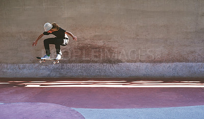 Buy stock photo Shot of a young man doing tricks on his skateboard at the skatepark