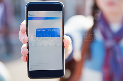 Buy stock photo Closeup shot of a university student holding up a cellphone with a rude text message