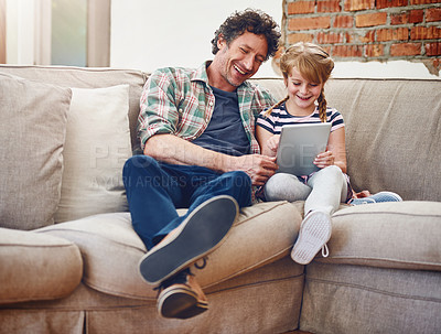 Buy stock photo Shot of a father and his little daughter using a digital tablet at home