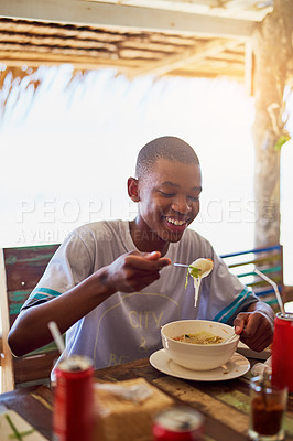 Buy stock photo Shot of a young man eating a bowl of noodles in a restaurant in Thailand