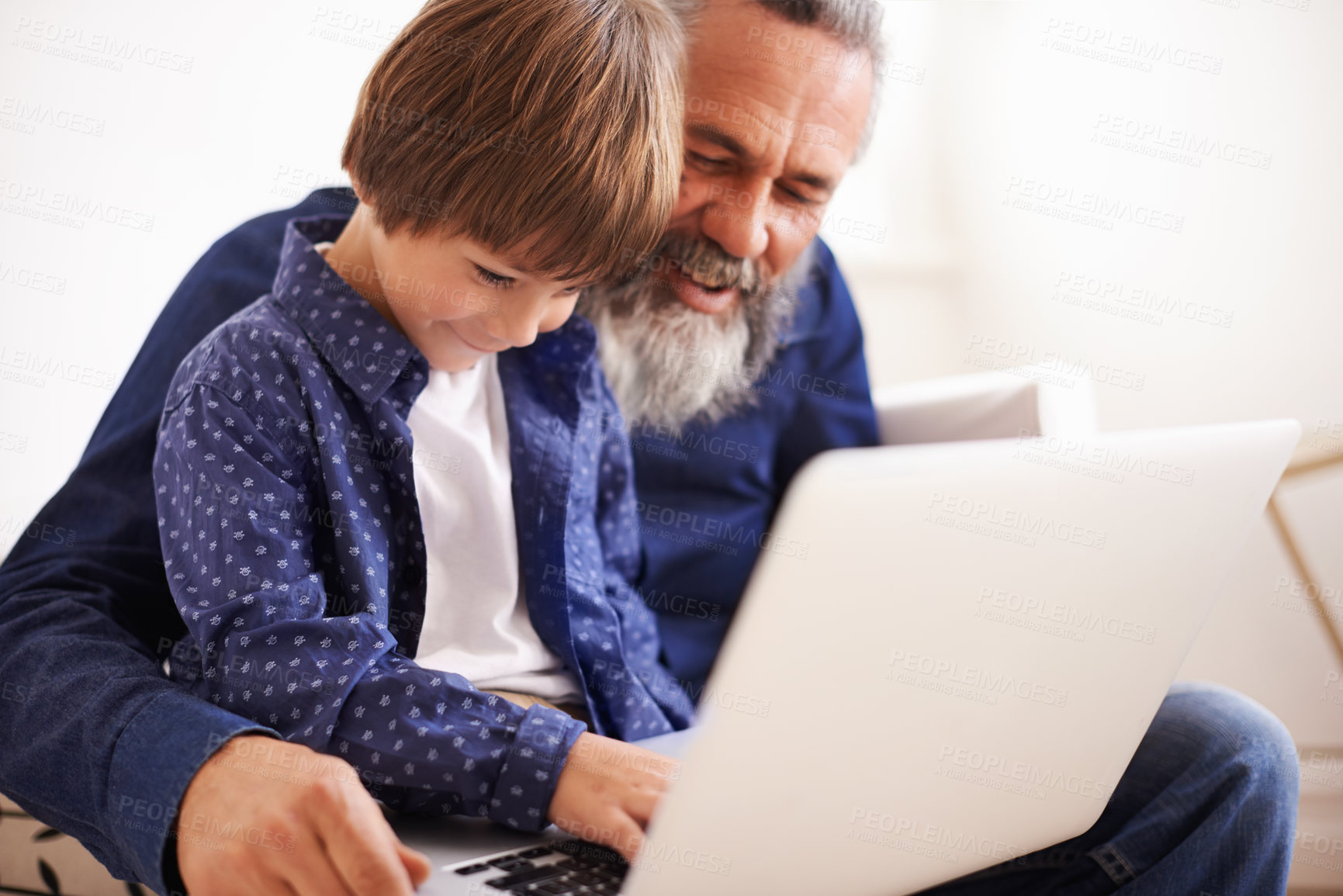 Buy stock photo Shot of a grandfather and grandson using a laptop together