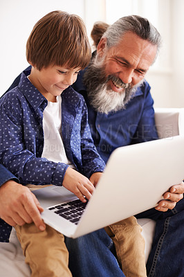 Buy stock photo Grandfather, laptop and boy child for streaming, elearning and bonding in living room. Focus, family and internet for play and son typing, childhood development and games or technology for learning