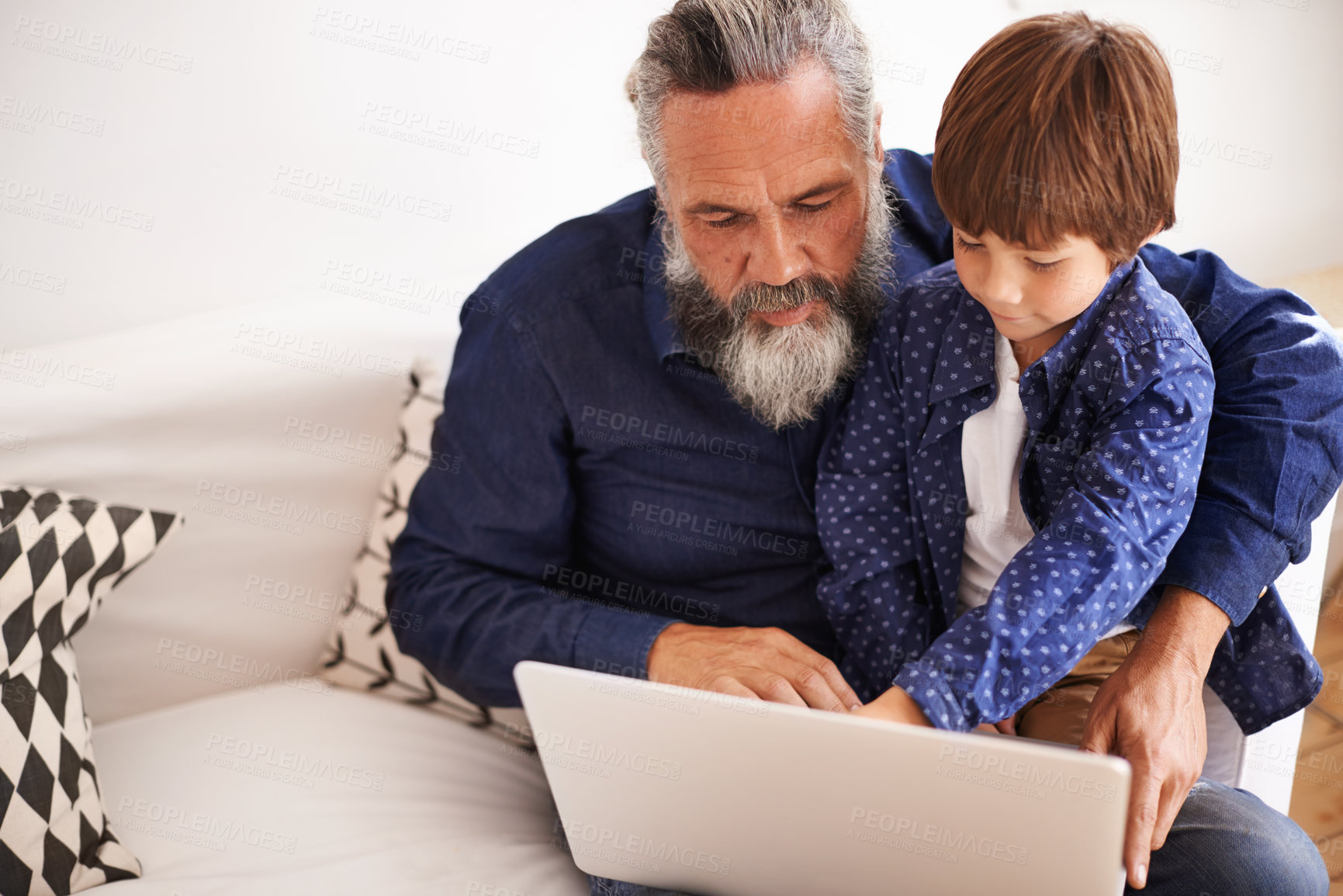 Buy stock photo Shot of a grandfather and grandson using a laptop together