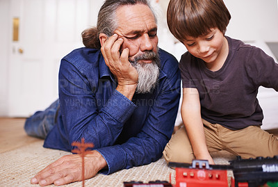 Buy stock photo Grandfather, kid and play with toy, train and fun in home or house with joy. Mature man, child and happiness with smile, youth and childhood development for future growth and bonding or care on floor