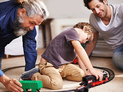 Buy stock photo Men, boy and playing with train toys, together for family time and fun with plastic railway track at home. Grandfather, father and kid with generations for games, playful and happy with bonding