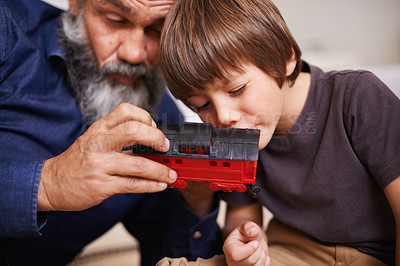 Buy stock photo Grandfather, toy and train with boy child, playing and bonding in family home. Grandpa, young kid and childhood development with games and fun, quality time and love with senior retired man 