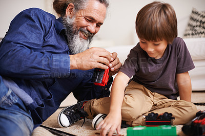 Buy stock photo Grandfather, laugh and toy train with boy child, playing and bonding in family lounge. Grandpa, young kid and childhood development with games and fun, quality time and love with elderly retired man 