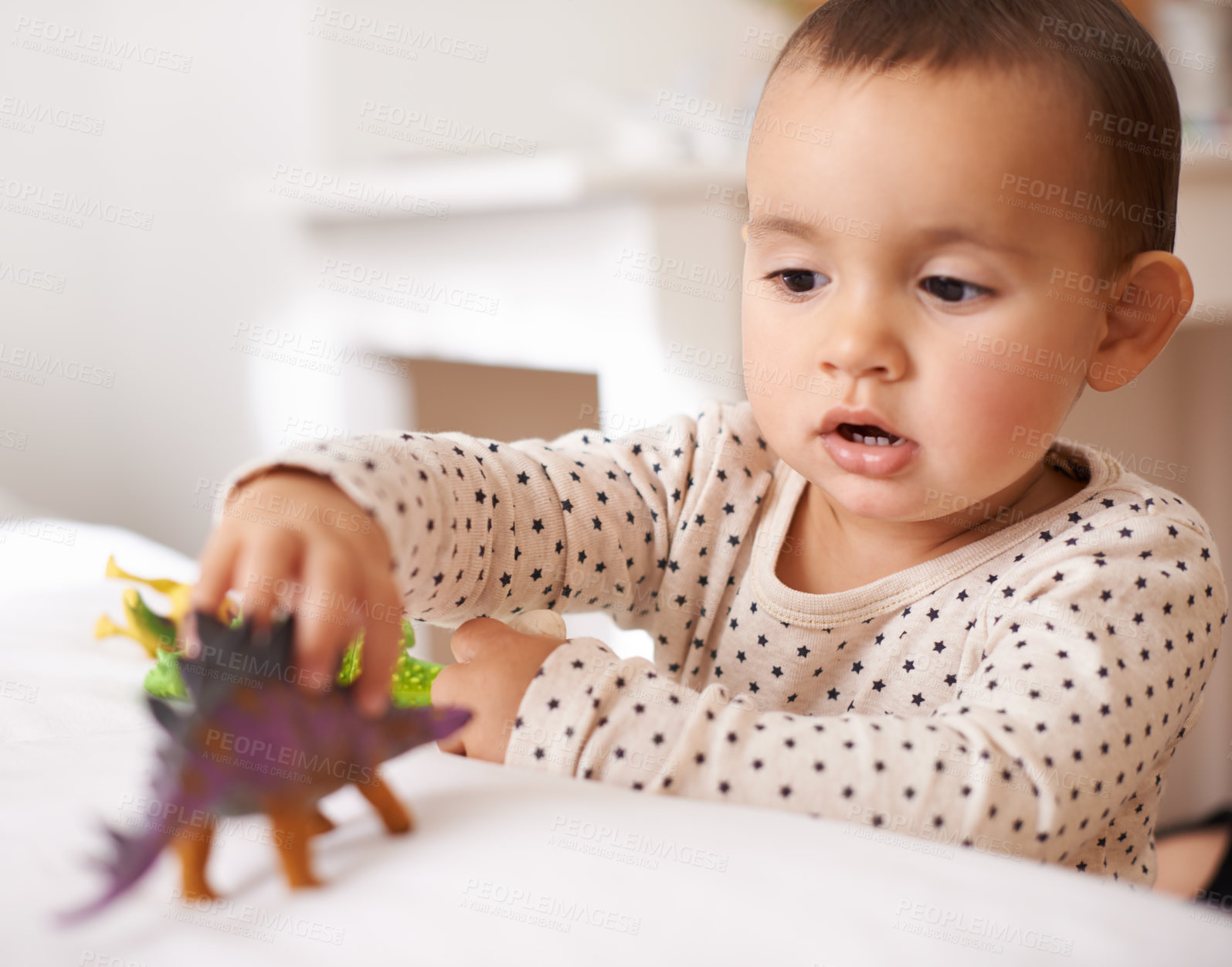 Buy stock photo Kid, toddler and play with toy in home, games and dinosaur for child development in bedroom. Person, girl and entertainment for enjoyment in childhood, curious and plastic animal for fun on bed