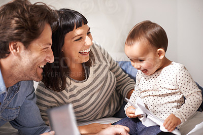 Buy stock photo Parents, toddler and tablet for laugh in home, online and happy for funny cartoon in bedroom. Family, child development and girl for streaming entertainment, website and app for series or movie