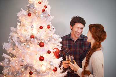 Buy stock photo Couple, Christmas and tree with champagne for celebration together for festive season or holiday vacation, decoration or lights. Man, woman and drinking alcohol in home or happy event, love or gifts