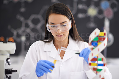 Buy stock photo Shot of a female scientist pouring liquid into a test tube