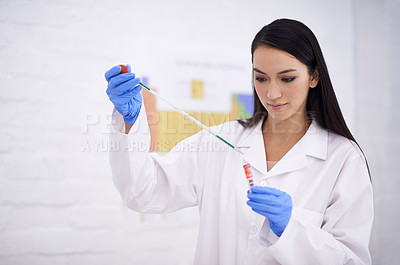 Buy stock photo Shot of a female scientist using a dropper on a test tube