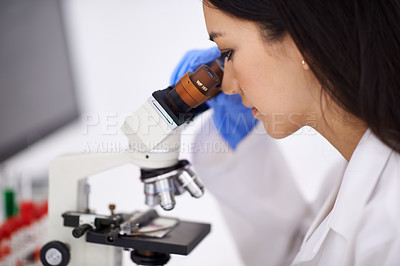 Buy stock photo Profile of a female scientist viewing a sample through a microscope