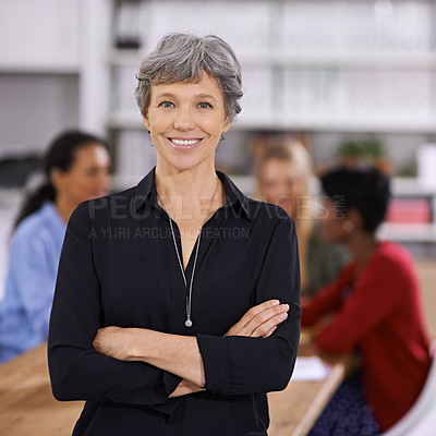 Buy stock photo Portrait of a confident mature businesswoman with her colleagues working in the background