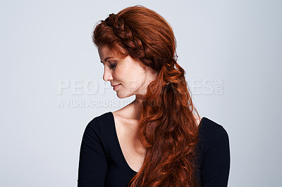 Buy stock photo Studio shot of a young woman with beautiful red hair posing against a gray background