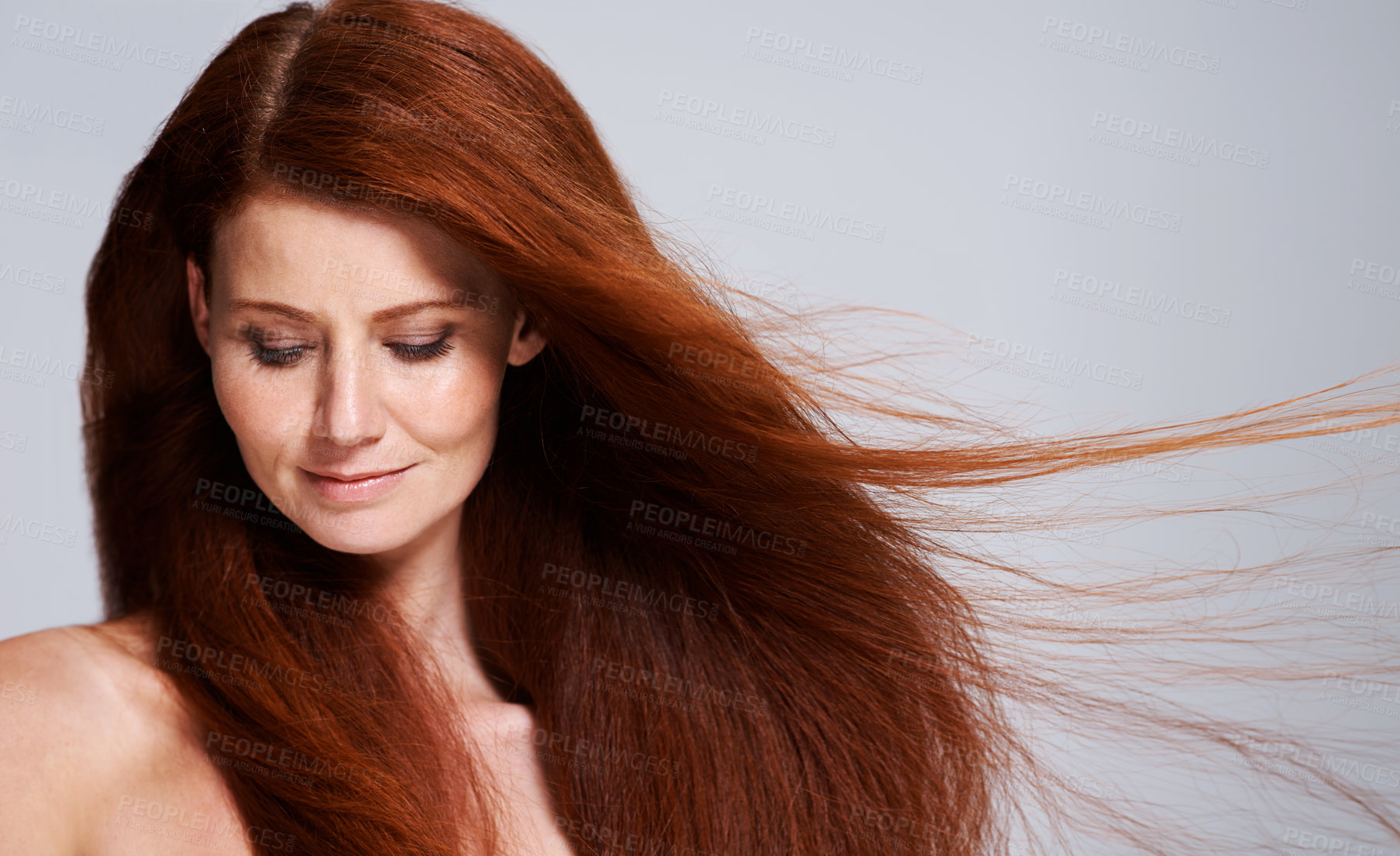 Buy stock photo Hair care, red head and woman with wind for keratin treatment, wellness and beauty on white background. Salon, hairdresser and female model face with shine, healthy and natural hairstyle in studio