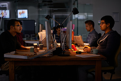 Buy stock photo Cropped shot of a group of young coworkers working in a dimly-lit office