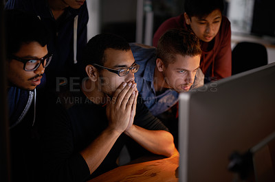 Buy stock photo Shot of a group of young designers staring tensely at a monitor