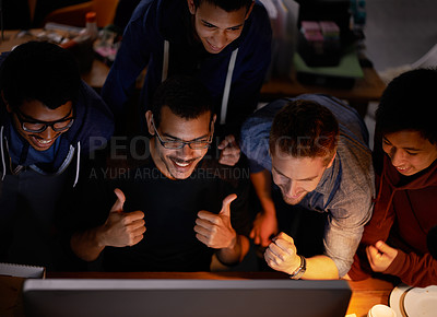 Buy stock photo Shot of a group of young man cheering at a monitor in a dark room
