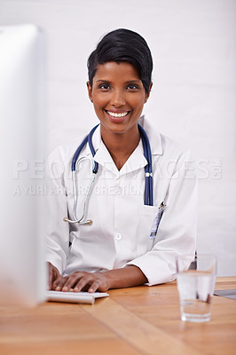 Buy stock photo Portrait, doctor and happy woman typing on computer in hospital for healthcare career in India. Face, smile and medical professional on keyboard for wellness and online research at desk in clinic