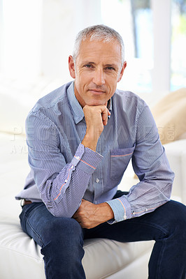 Buy stock photo Portrait of a thoughtful mature man sitting on a sofa