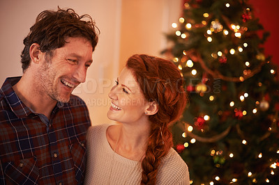 Buy stock photo Couple, smile and Christmas, holiday celebration with festive season of giving for love and commitment. Happiness, hug and support with people at home for tradition, romance and relationship