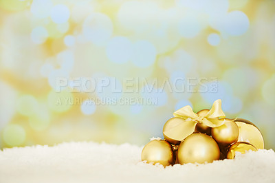 Buy stock photo Shot of a group of golden Christmas ornaments against a textured background