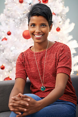 Buy stock photo Portrait of a beautiful young woman sitting next to her Christmas tree at home