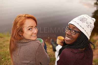 Buy stock photo High angle portrait of two happy teenage girls sitting beside a lake