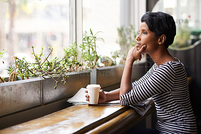 Buy stock photo An attractive young woman looking thoughtful while having coffee at a cafe