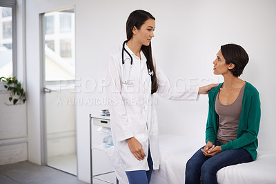 Buy stock photo Shot of a young woman getting news from her doctor at a clinic