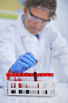 Buy stock photo A cropped shot of a mature scientist working with blood samples in his lab