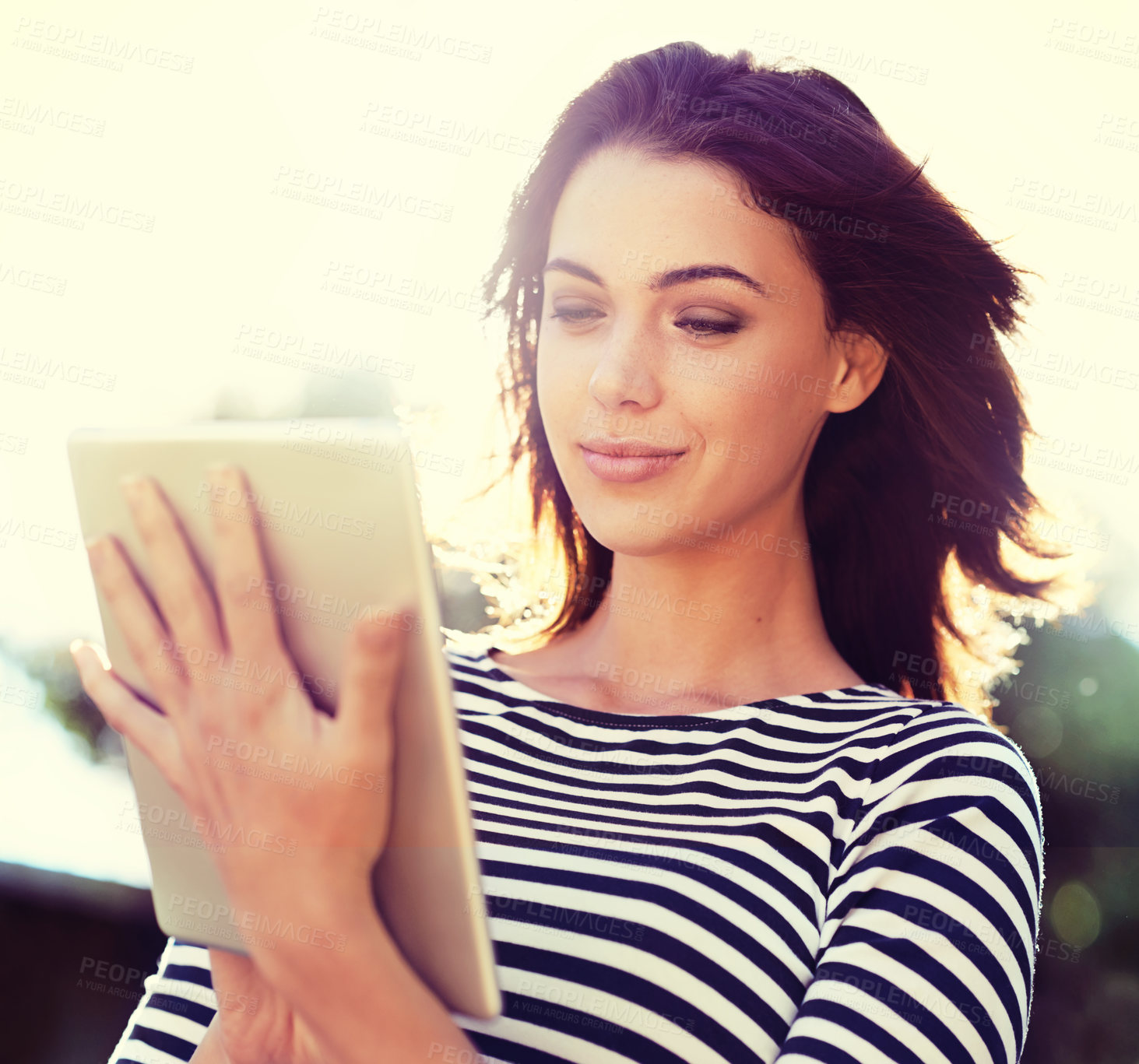 Buy stock photo Woman, nature and smile in sunshine with tablet for digital communication, social media or reading blog. Happy, female person and technology outdoors for internet, connection and game with low angle