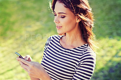 Buy stock photo Young woman, cellphone and networking to relax in nature and typing a message for connection. Lady, smartphone and scroll for travel app to download, england and update on social media in countryside
