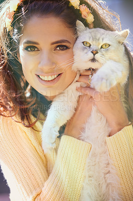 Buy stock photo Portrait of a woman holding her persian cat. A cute young tanned girl smiling and hugging her grumpy british longhair to her face. Beautiful female with a flower crown showing her adorable angry pet 