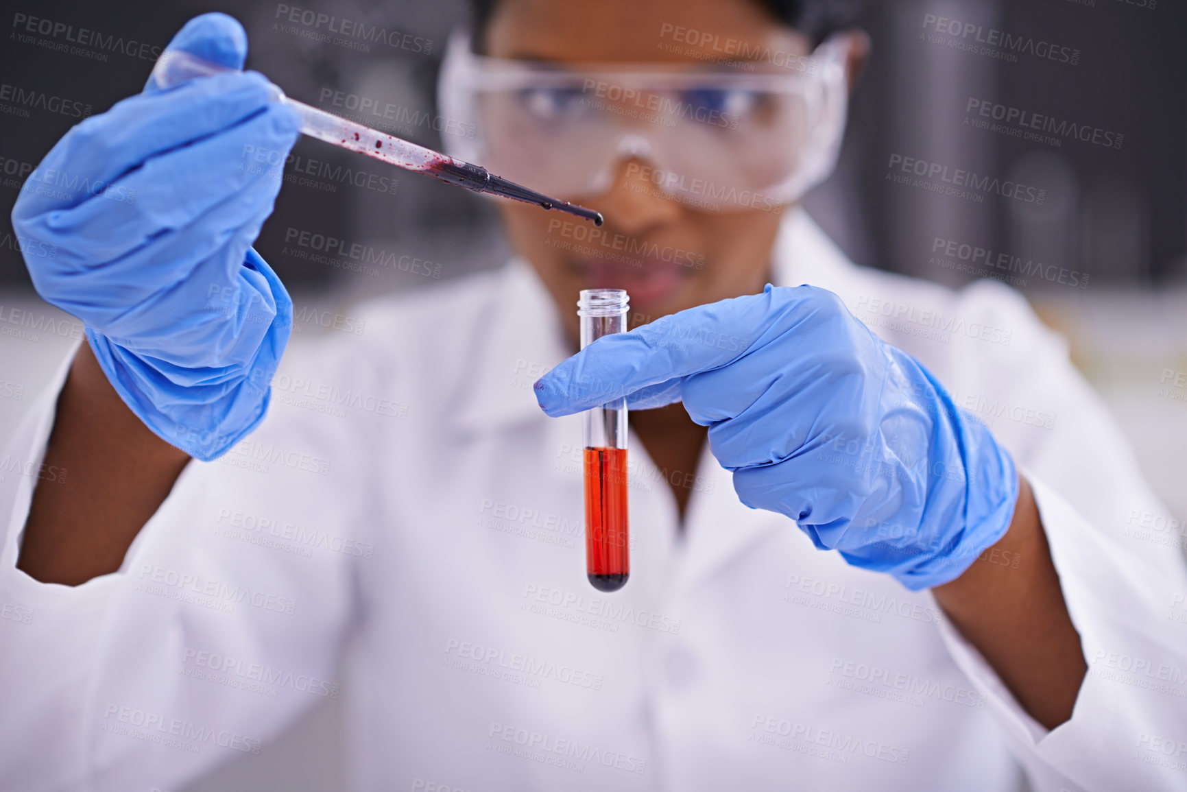 Buy stock photo A front view of a young scientist dropping a substance into a test tube