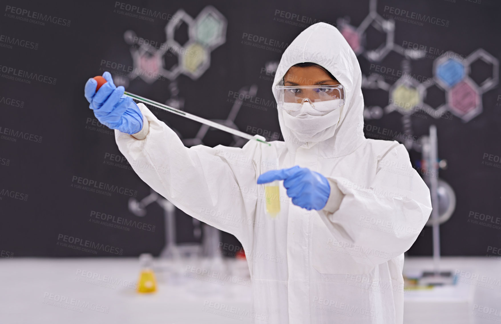 Buy stock photo A young scientist in protective clothing using a pipet in her lab