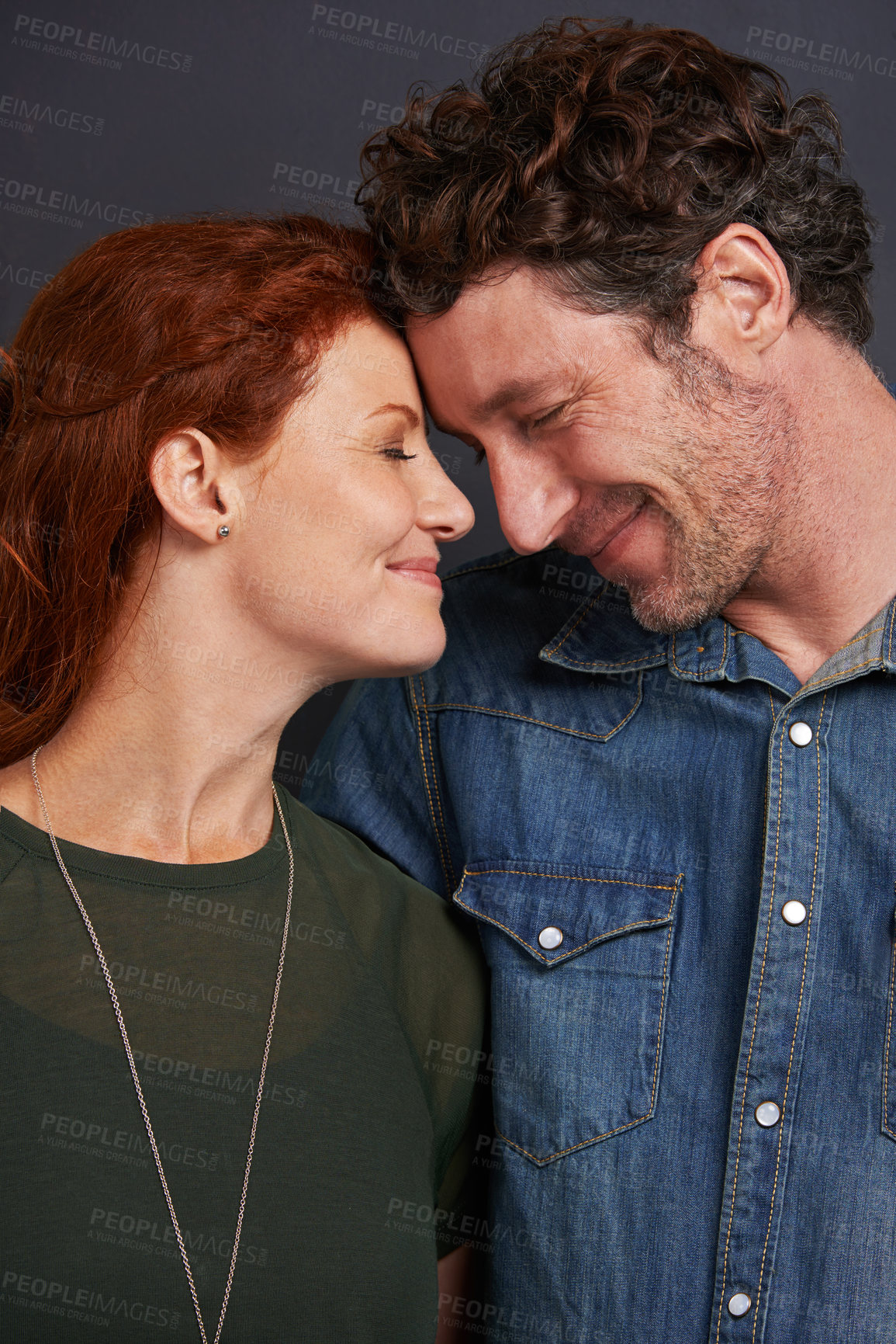 Buy stock photo Studio shot of a happy couple standing face to face and smiling