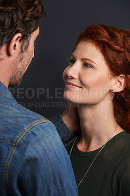 Buy stock photo Love, smile and couple embrace in studio with relationship trust, care and support. Romance, man and woman hug on dark background with commitment, loyalty and affection in happy marriage together