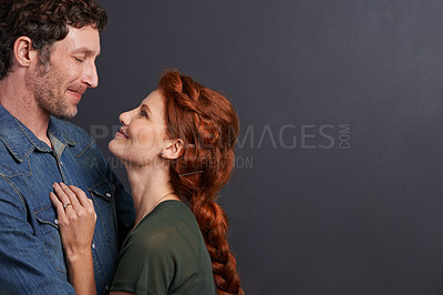 Buy stock photo Love, smile and happy couple in studio mockup together with relationship trust, care and support. Romance, man and woman embrace on dark background with commitment, loyalty and affection in marriage